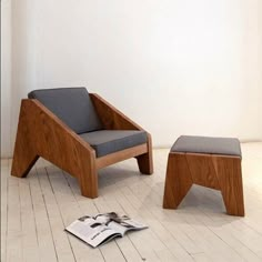 a chair and footstool sitting on the floor next to each other with a magazine underneath them