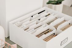 an open file cabinet filled with files on top of a table