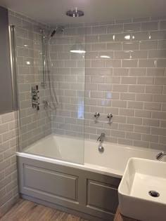 a bath tub sitting next to a white sink under a faucet in a bathroom