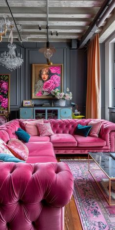 a living room with pink couches, chandelier and paintings on the walls