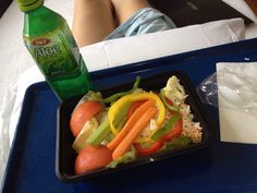 there is a plastic tray with food in it and a bottle of soda on the side