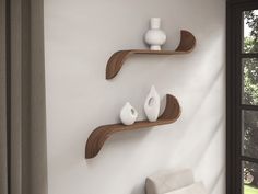 two wooden shelves with white vases on them against a wall in a living room