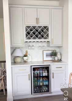 an open refrigerator in a kitchen with white cabinets