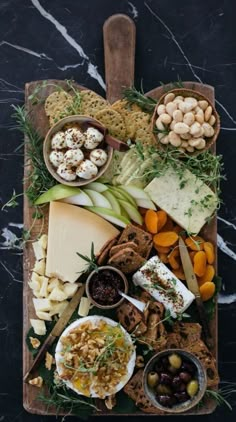 an assortment of cheeses and crackers on a platter