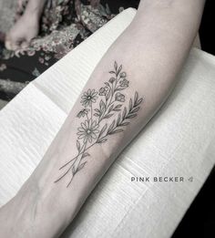 a woman's arm with flowers and leaves tattooed on the left side of her leg