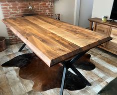 a wooden table sitting on top of a hard wood floor next to a fire place