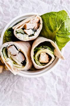 a white bowl filled with spinach and chicken wraps