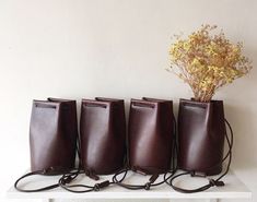 "Classic yet contemporary bucket bag, combined a minimalism and functional. The body made from Italian vegetan leather, using leather cord for the shoulder strap. The shoulder strap is adjustable, able to enjoy this bag for 3 ways as a crossbody bag, one-shoulder bag and handbag. Has a card sized inside pocket. Approximate Dimensions: W 4.75\" x H 8\" x D 4.75\" W 12cm x H 20cm x D 12cm Inside pocket W 3.50\" x H 3.50\" W 9.5cm x H 9.5cm - 100% Vegetable tanned leather (body) - Genuine leather c Cheap Chic Pouch-shaped Bucket Bag, Mini Bucket Bag, Leather Weekender Bag, Leather Key Case, Mini Bucket Bags, Mini Bucket, Leather Key Fobs, Leather Keyring, Travel Jewelry Case