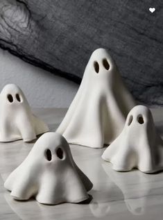 three white ghost figurines sitting on top of a table