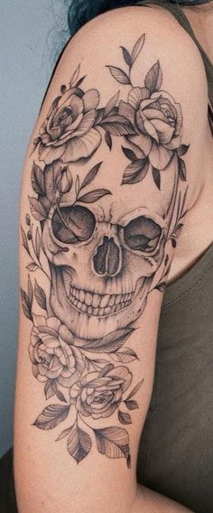 a woman with a skull and roses tattoo on her arm