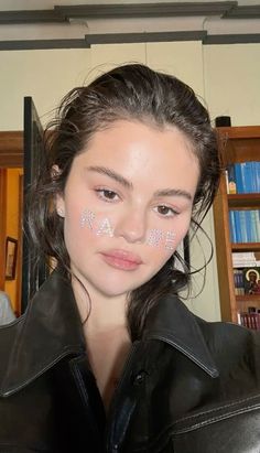 a young woman with white letters painted on her face