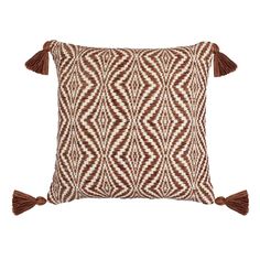 a brown and white pillow with tassels