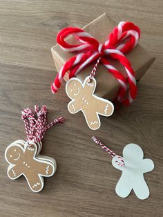 two gingerbread cutouts are tied up with twine and string on a wooden table