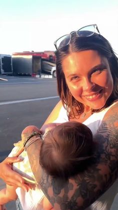 a woman holding a baby in her arms on the tarmac at an air port