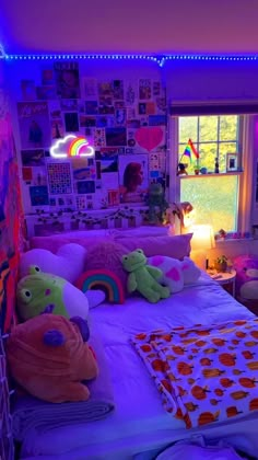 a bed with lots of stuffed animals on it in a room that has purple lighting