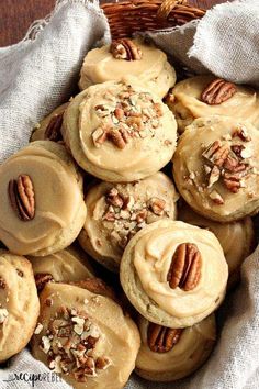 a basket filled with cookies covered in frosting and topped with pecans, nuts