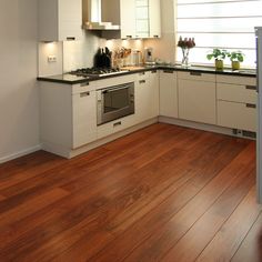 a kitchen with wooden floors and white cabinets