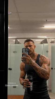 a man taking a selfie in front of a bathroom mirror with his cell phone