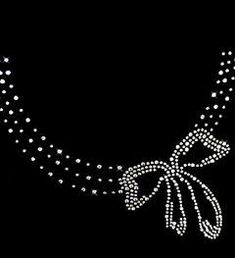 an image of a necklace with pearls and bows on black background framed print by panoramic images