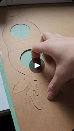 a person is cutting out a cardboard box with scissors and glue on the bottom half