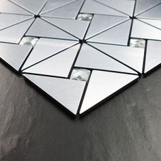 a close up of a mirror on a table with black and white tiles in the background