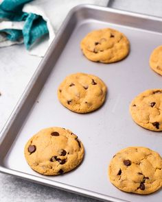 six chocolate chip cookies on a baking sheet ready to be baked in the oven or used as an appetizer