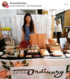 a woman standing next to a table full of items