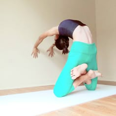 a woman is doing a handstand on the floor