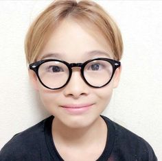 a woman with glasses on her face posing for the camera