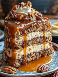 a piece of cake on a plate with pecans and caramel drizzle