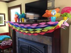 colorful kites hanging from the ceiling above a tv