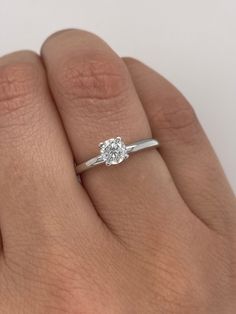 a woman's hand with a diamond ring on it