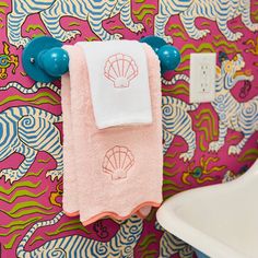 a towel hanging on the wall next to a white sink and blue faucet