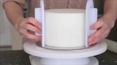 a person is using a device to make a cake with white frosting on it