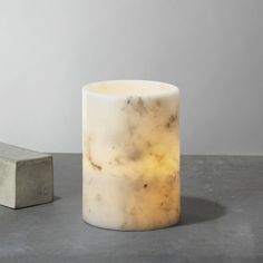 a marble candle holder next to a concrete block