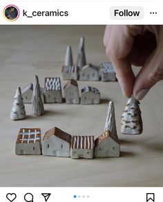 someone is playing with miniature houses and trees