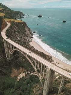 an aerial view of a bridge over the ocean with cars driving on it's sides