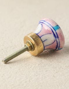 a close up of a screw on the ground with a white and blue design painted on it