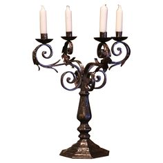 an iron candelabra with four candles on it