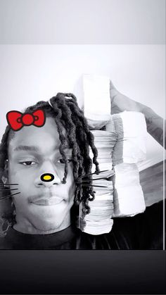 a man with dreadlocks and a cat's head on top of stacks of papers