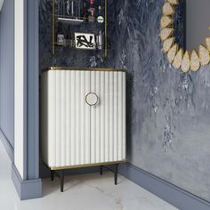 a white cabinet sitting in front of a mirror on top of a wall next to a shelf