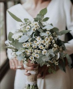 a woman holding a bouquet of flowers in her hands