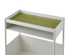 a small white shelf with green carpet on the top and bottom shelves, against a white background