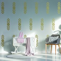 a baby's room with a crib, chair and wallpaper