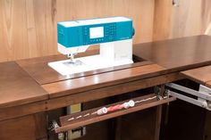 a sewing machine sitting on top of a wooden table next to a drawer with drawers