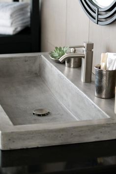 a bathroom sink sitting under a mirror next to a towel dispenser and toiletries