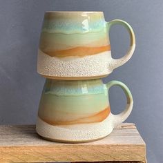 two coffee mugs stacked on top of each other