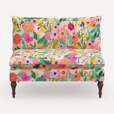 an upholstered floral couch with wooden legs