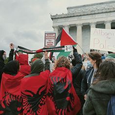 people holding flags and banners in front of the lincoln memorial