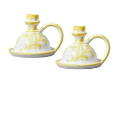 two yellow and white teapots sitting next to each other